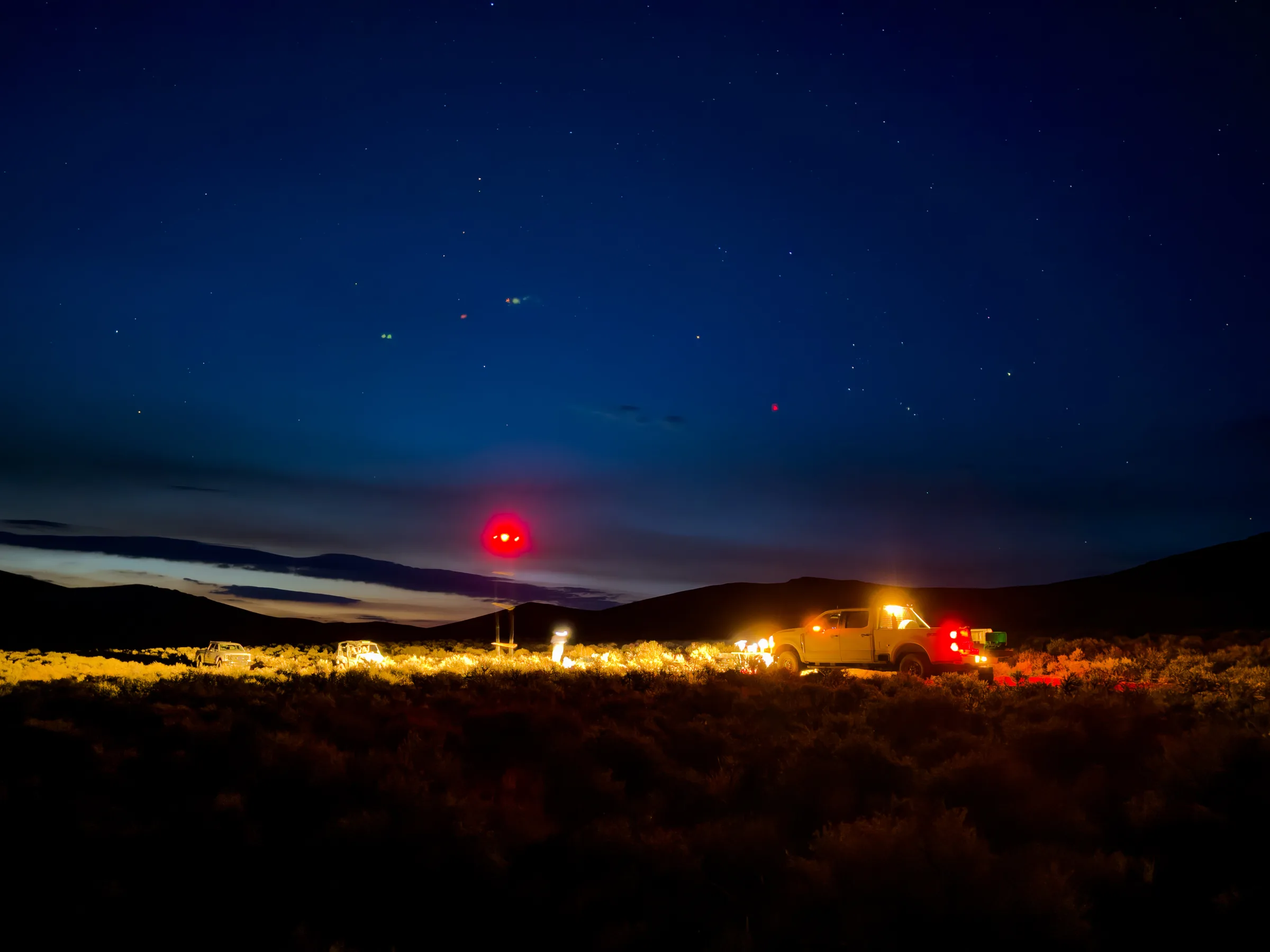 UAV magnetic survey crew working at night beneath a star-filled sky